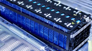 A close up of a battery, showing blue cells packed in with black scaffolding. 