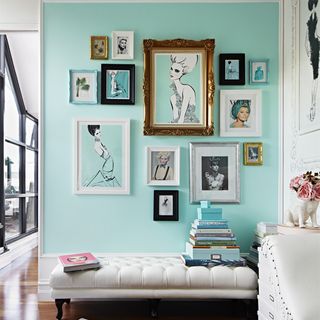 frames on green wall and books