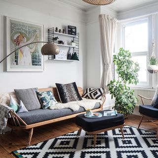 living area with white wall and wooden floor and rug