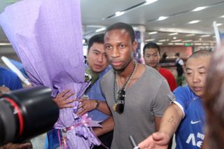 Seydou Keita is greeted by Chinese fans and media at the airport after his arrival in Dalian to sign for Dalian Aerbin in July 2012.