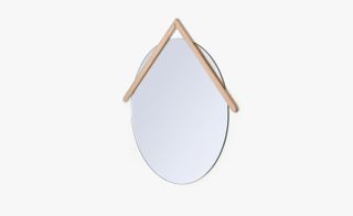 An oval wall mirror with a triangular wooden frame on top of it.