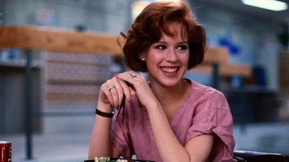 Molly Ringwald sits at a desk eating lunch in the Breakfast Club