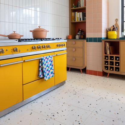 Yellow range cooker on terrazzo tiles with white metro tile backsplash