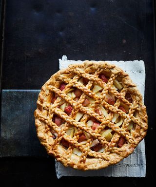 Rhubarb and Apple Lattice Pie, Overhead view of a fruit pie on a grey tablecloth and dark table