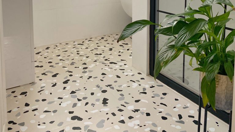 Beige bathroom tiles with terrazzo stencil in white and black pattern