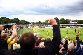 Sutton United players and fans celebrate a goal against Oldham Athletic in August 2021.