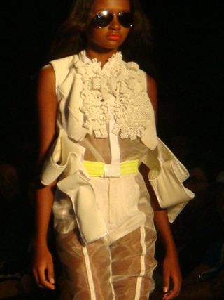 Model wearing a cream outfit with ruffles and sheer panels