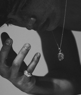 black and white image of man wearing ring
