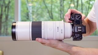 Canon RF 200-800mm F6.3-9 lens in the hand set to 200mm, mounted to a Canon EOS R5