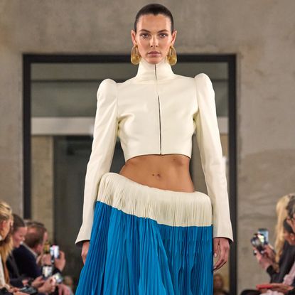 a model walks the Alaïa fall 2025 runway wearing a skirt that exaggerates the shape of her hips