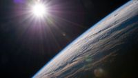 An image of the earth with the sun shining in the top left.
