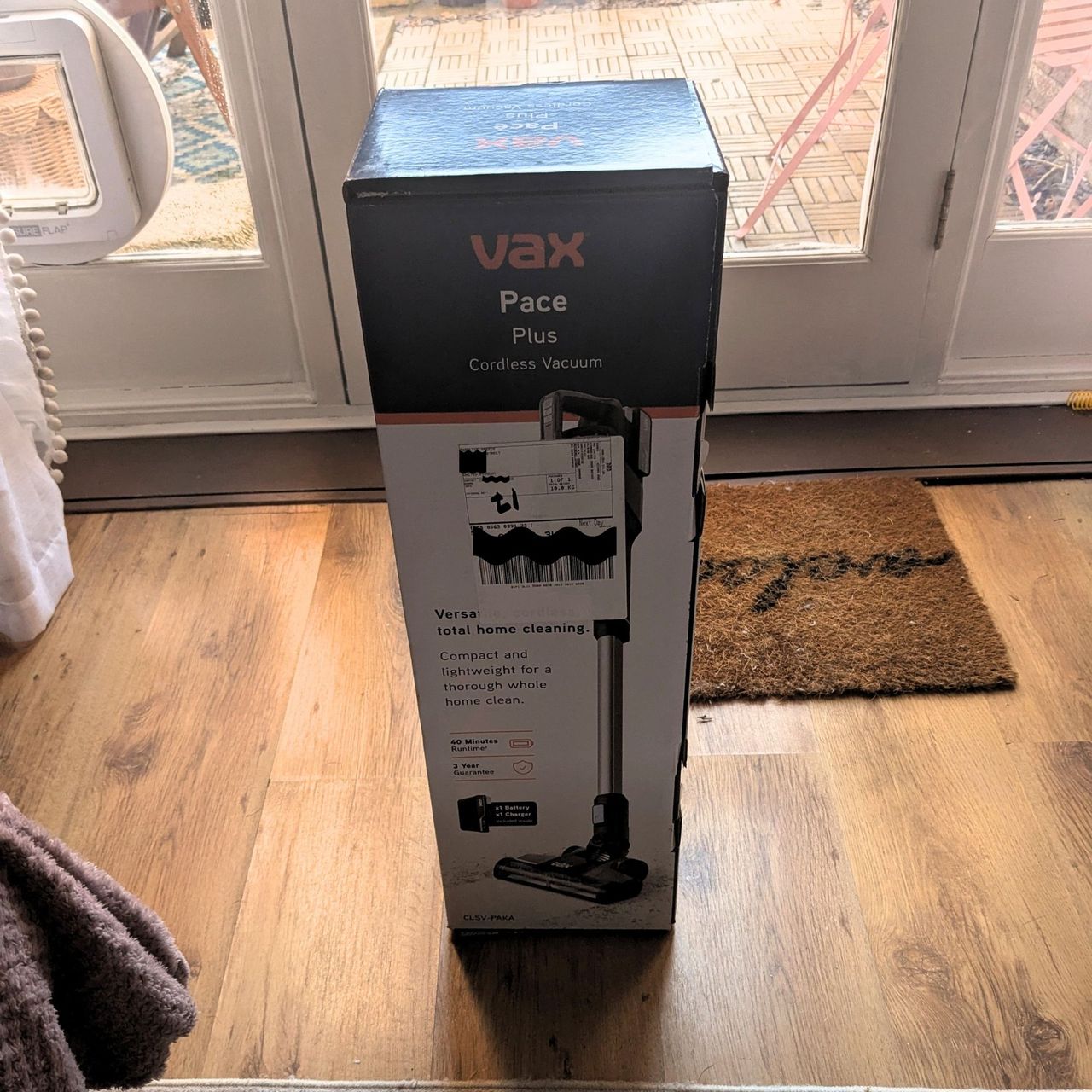 VAX Pace Plus Cordless Vacuum Cleaner box in front of patio doors, on wood-effect flooring