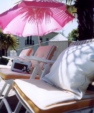 White sun loungers with a pink parasol