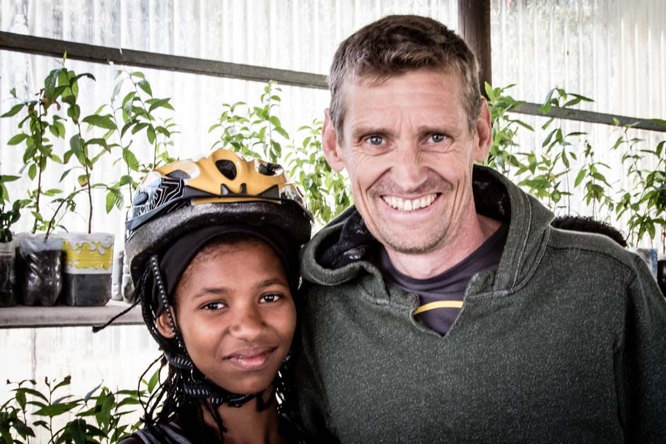 Rolf Aldag poses for a photo with one of the children who was handed a bike
