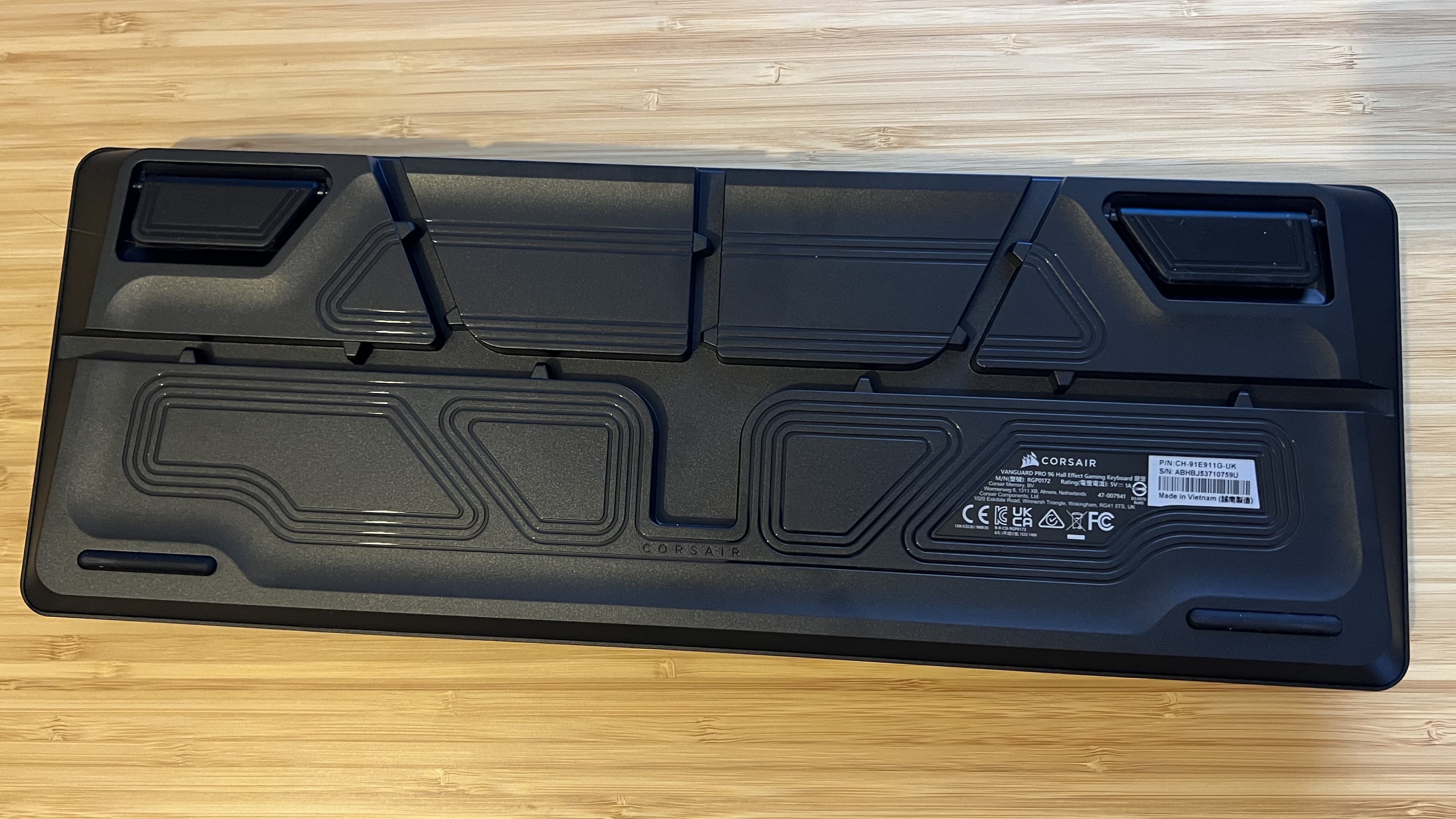 Underside of Corsair Vanguard Pro 96 gaming keyboard showing cable runners and elevation feet