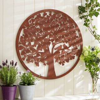white garden wall with rusty metal wall plaque