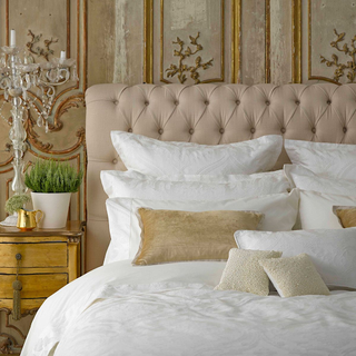 layered pillows and cushions against a soft material headboard