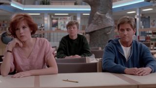 Molly Ringwald and Emilio Estevez sitting next to each other, with Anthony Michael Hall sitting behind them in The Breakfast Club