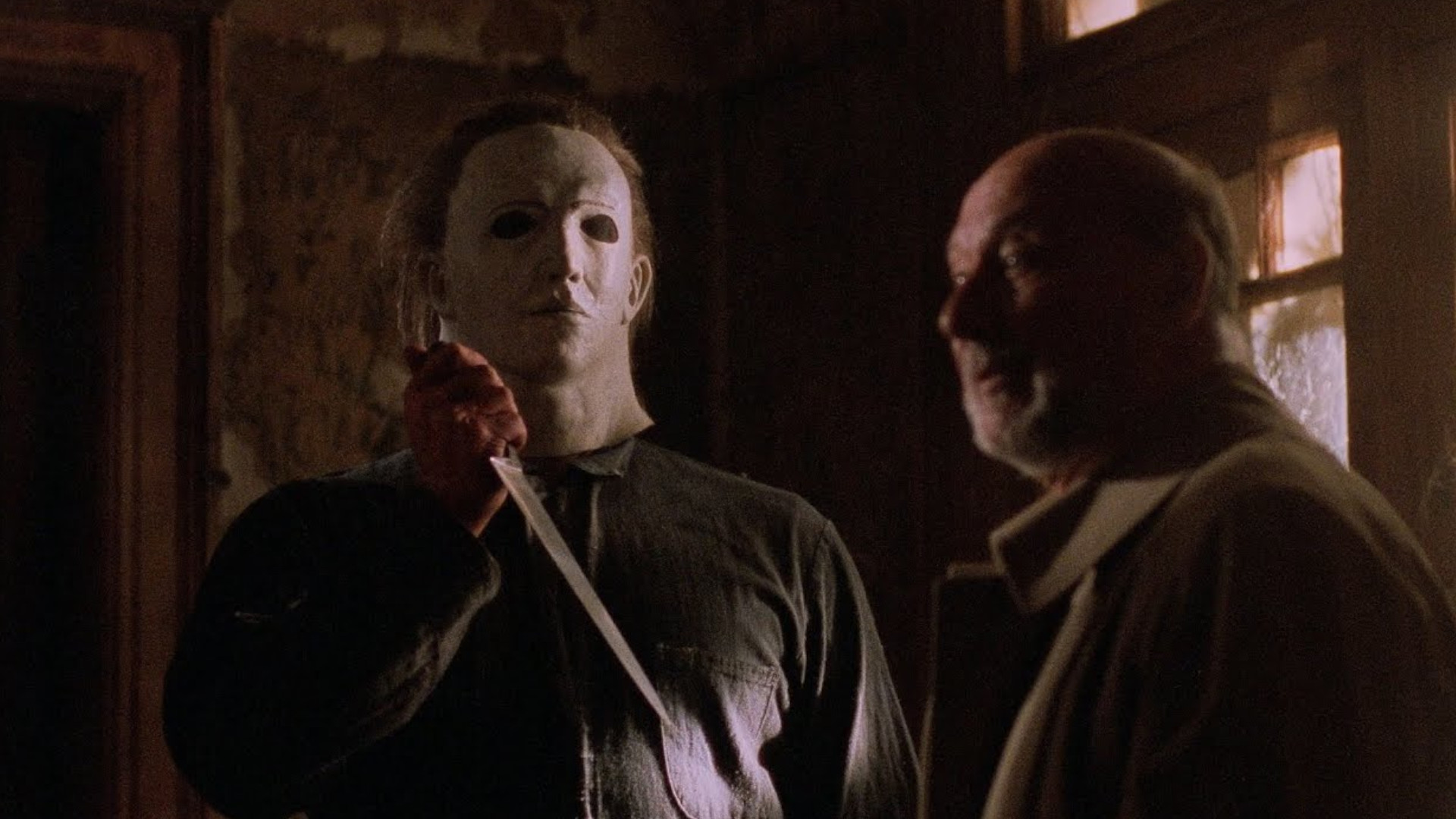 Michael Myers holding a knife next to Dr Loomis during Halloween 5: The Revenge of Michael Myers.