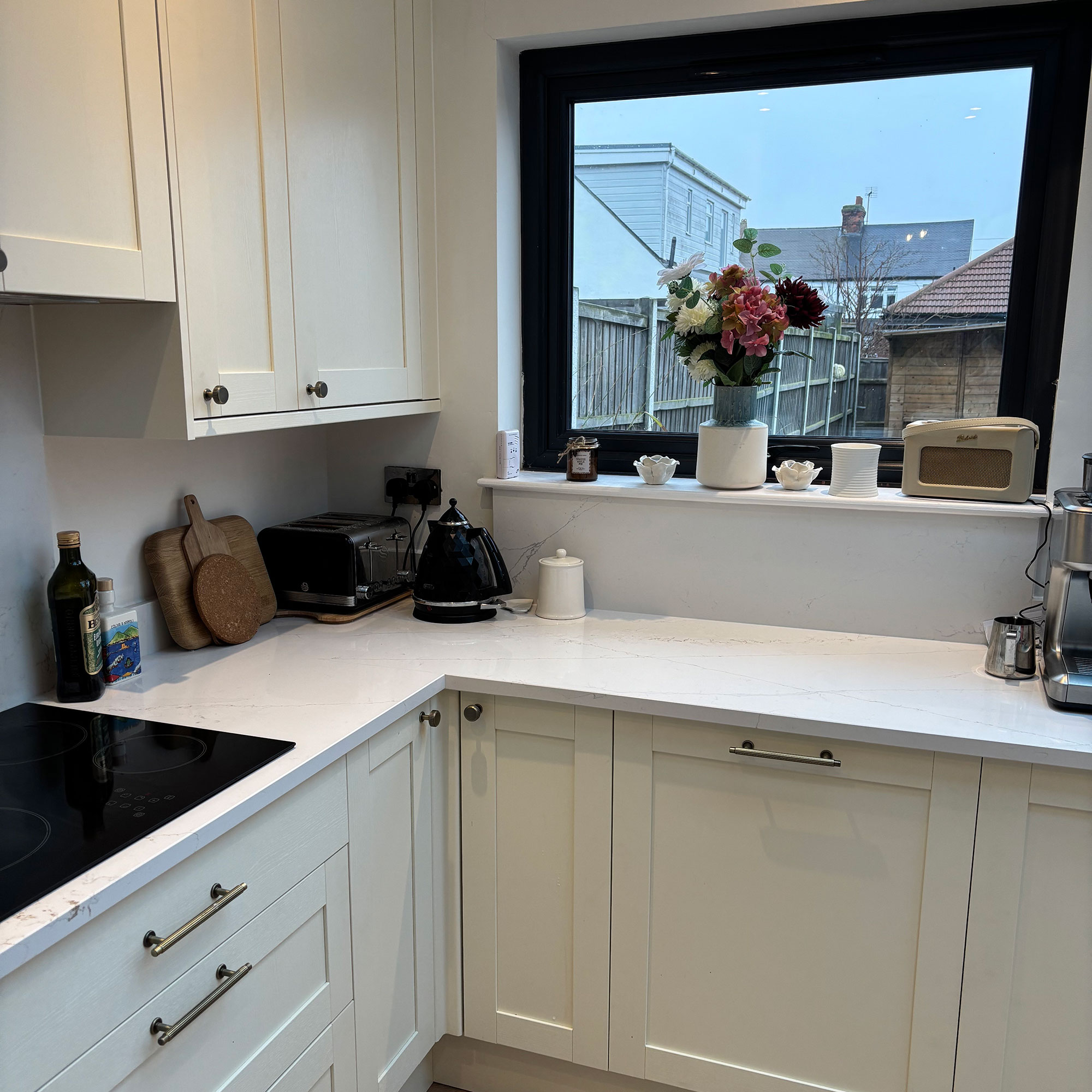 White kitchen with marble effect counter and splashback