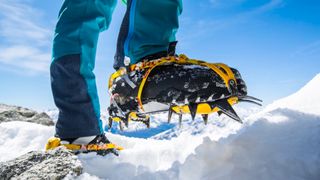 Man's feet wearing Grivel G12 crampons in snow