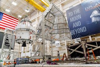 NASA's Orion spacecraft is lifted into a thermal cage ahead of its move to to the vacuum testing chamber at NASA's Plum Brook testing station in Sandusky, Ohio. The spacecraft will fly on the Artemis 1 mission, an uncrewed test flight that will launch on NASA's new Space Launch System megarocket sometime in 2021. After that mission, NASA plans to use the Orion spacecraft to fly astronauts to the moon.
