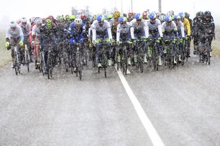 The peloton races under snowy conditions on stage one of the 2016 Paris-Nice