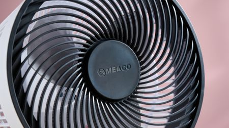 The magnetic circular remote sits on the middle of the fan's grill.