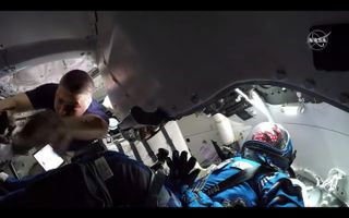 NASA astronaut Kjell Lindgren works to get Boeing's Starliner capsule ready for hatch closure on May 24, 2022 as the dummy Rosie the Rocketeer looks on.