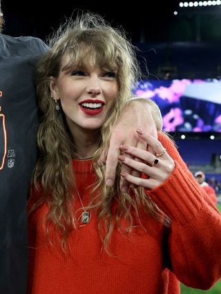 Taylor Swift wearing a red sweater