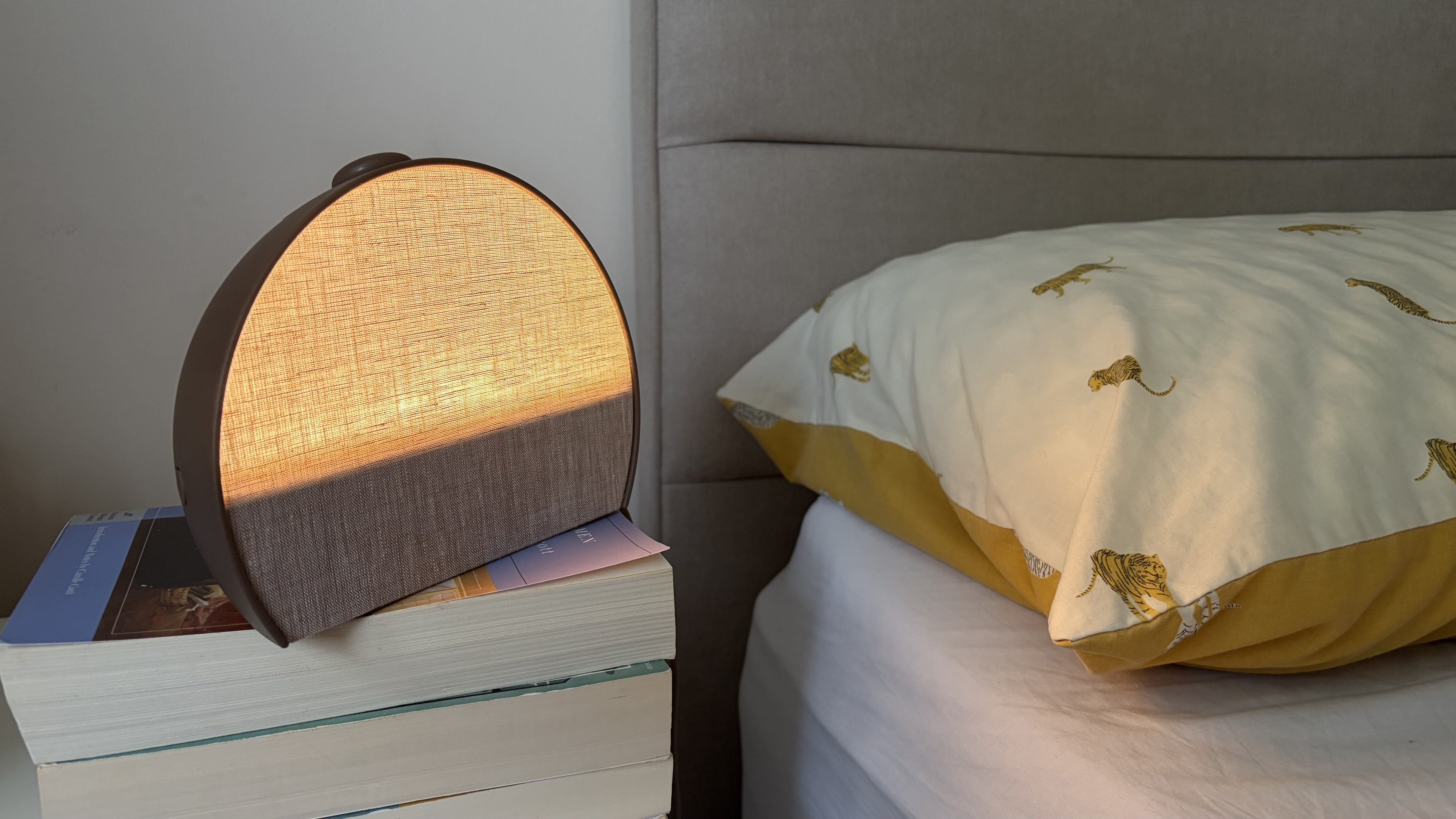 The new Hatch Sleep Clock on a white wooden nightstand in our reviewer's bedroom