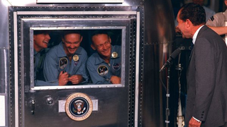the three apollo 11 astronauts in a quarantine facility speaking to president richard nixon after returning to the moon in 1969