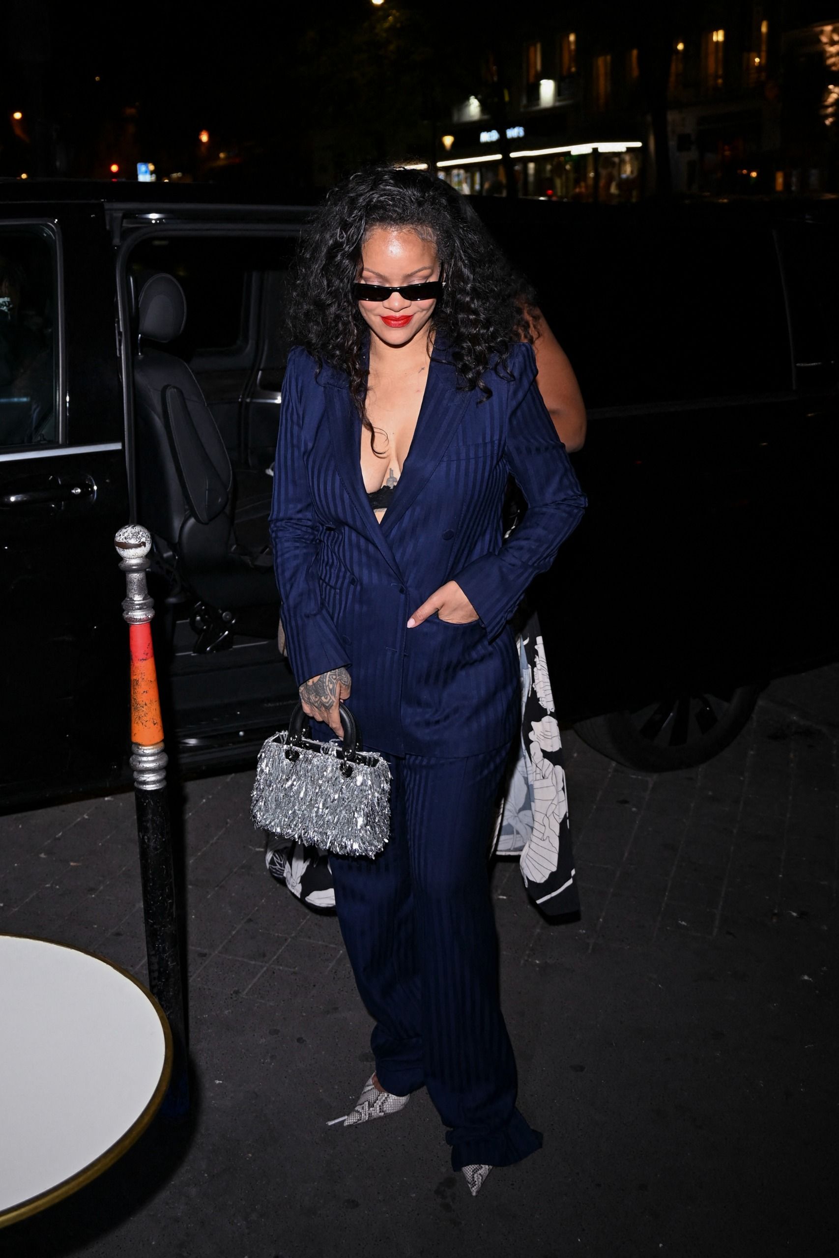Rihanna wore the peekaboo bra trend with a pinstripe suit and a bedazzled Dior bag at Céline Dion's concert in Paris