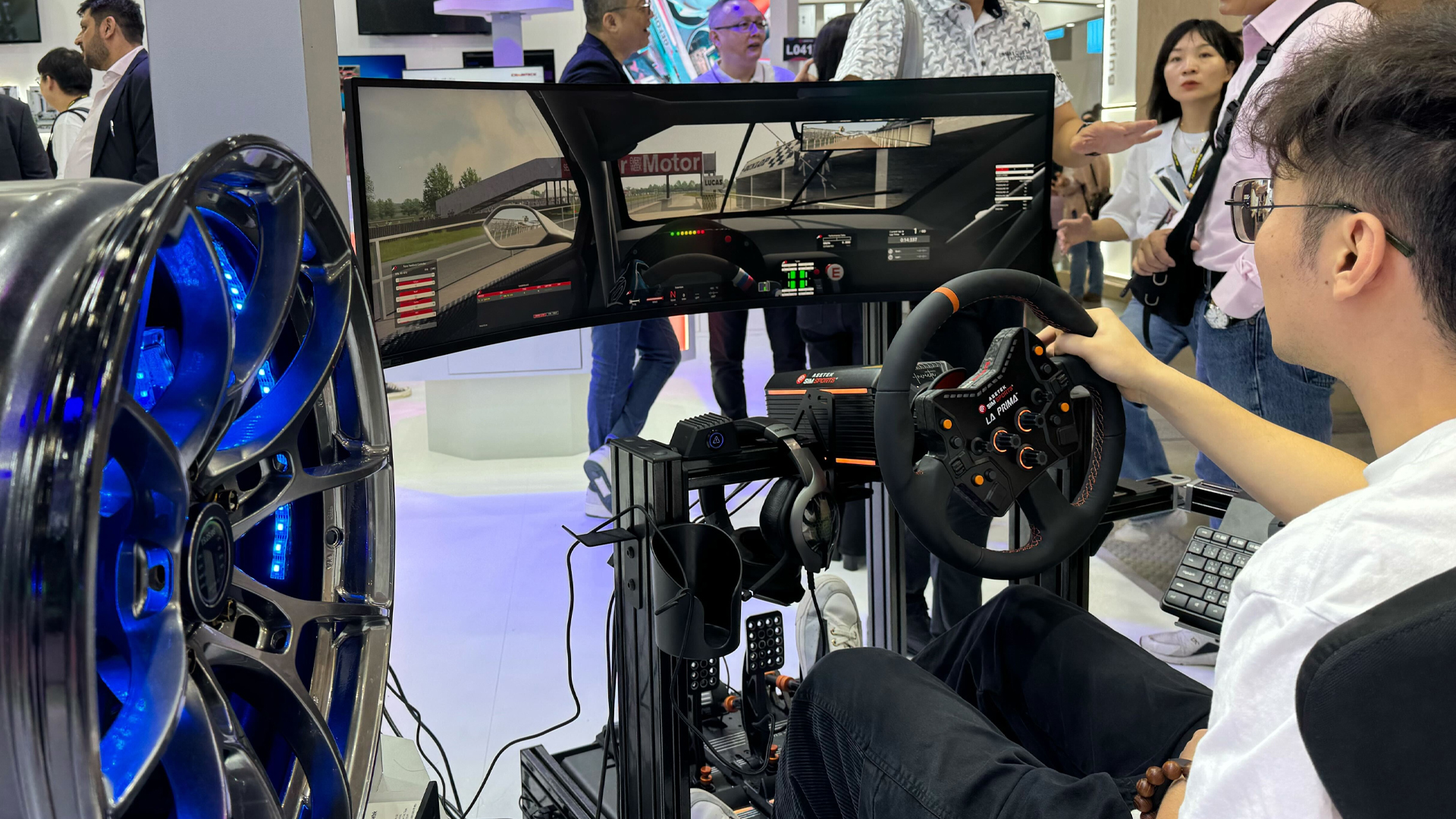 Homme jouant à un jeu sur le cockpit de simulation de course Thermaltake GR500 au Computex 2024.