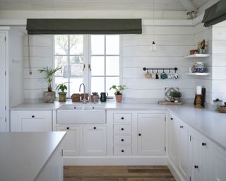 White kitchen with cladding in Cornish coastal newbuild