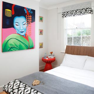 Bedroom with painting on wall and white walls