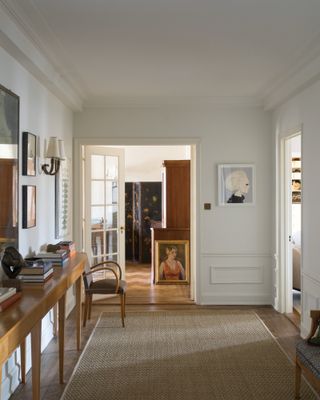 Hallway with soft off-white walls, wooden console and artwork