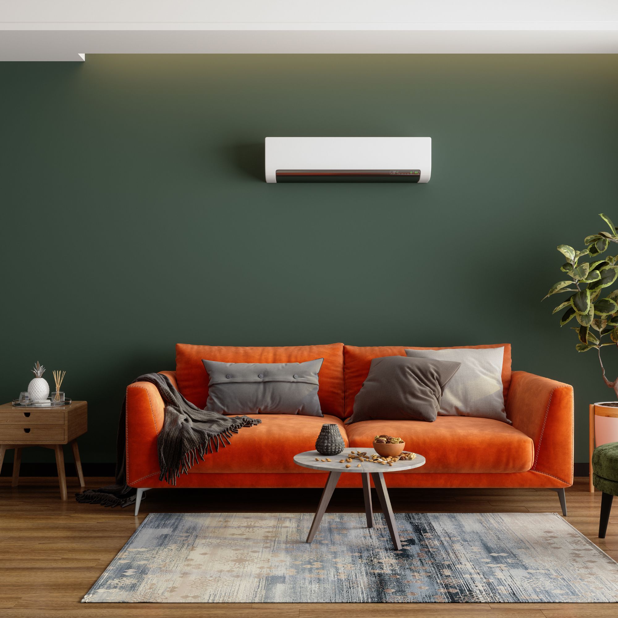 Air conditioning unit mounted on a green wall above an orange sofa with grey cushions and a small green accent chair to the side