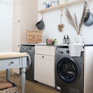 Washing machine and dryer in utility room with light colour scheme