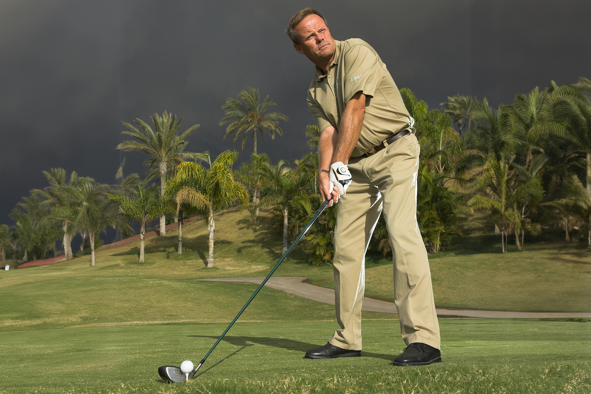 Gary Alliss standing in the address position with driver on the tee box, looking down the fairway with the clubhead settled behind the golf ball