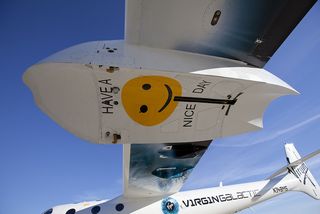 The Virgin Galactic team shows a sense of humor with a sign on the undercarriage of WhiteKnightTwo, the mothership for the company's SpaceShipTwo suborbital spacecraft..