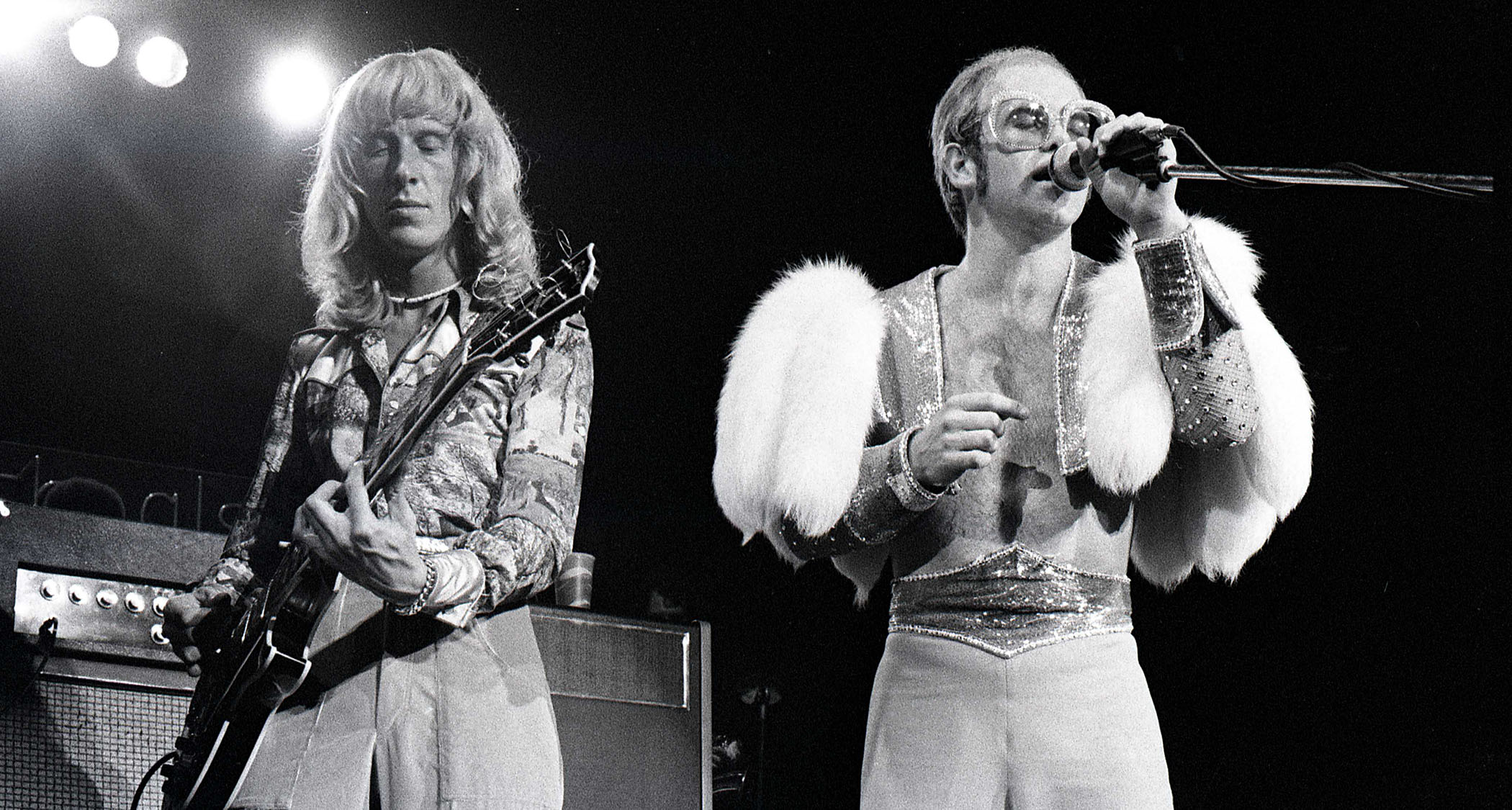 A classic black-and-white live shot of Davey Johnstone and Elton John performing in 1974