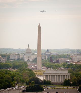 Space shuttle Discovery, mounted atop a NASA 747 Shuttle Carrier Aircraft (SCA) is seen from Top of the Town in Arlington, Virginia as it flies near the U.S. Capitol, Tuesday, April 17, 2012, in Washington.