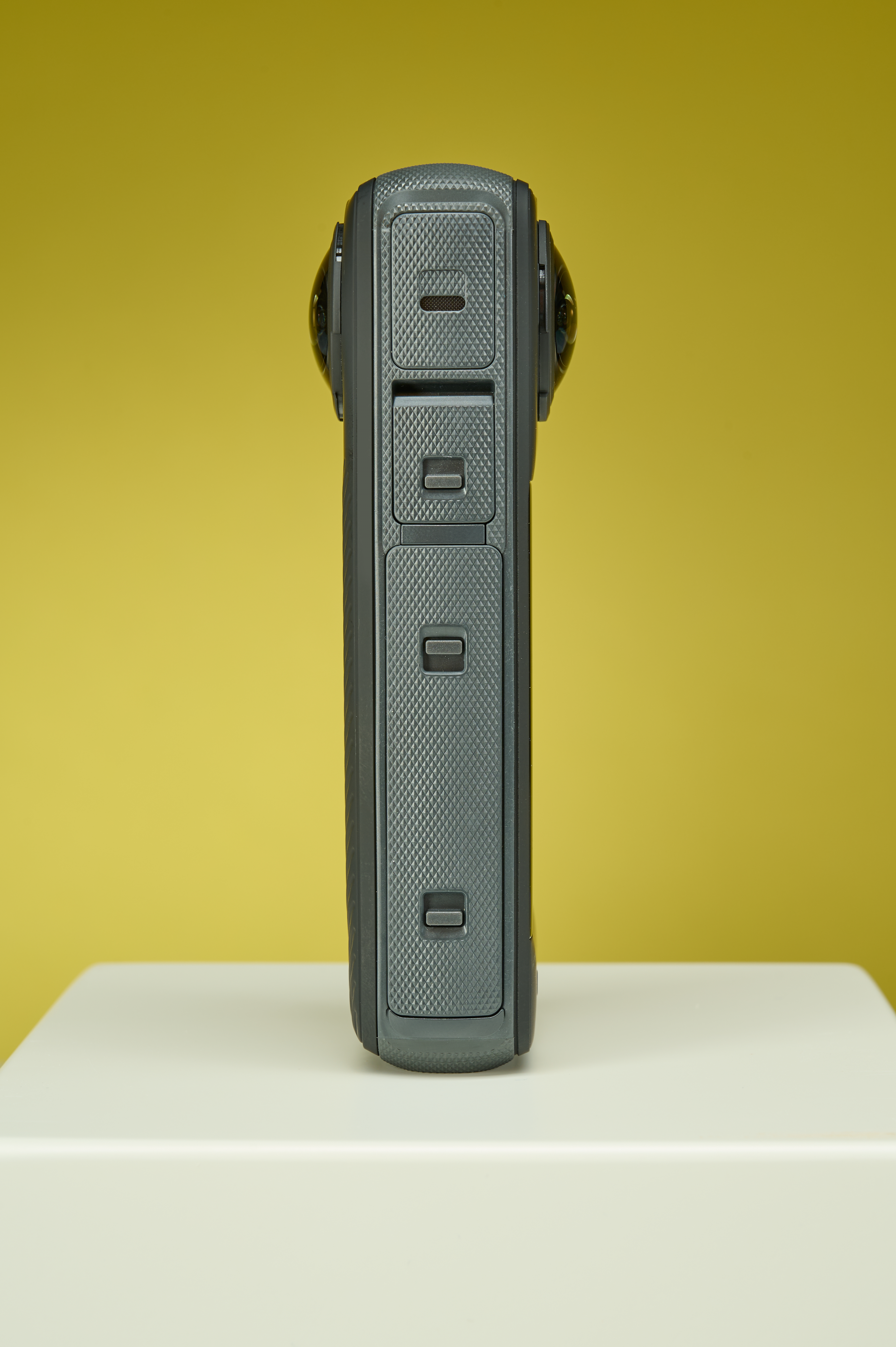 Side-on profile of the Insta360 X4 with its scuba diving style helmet lens covers just popping out on either side