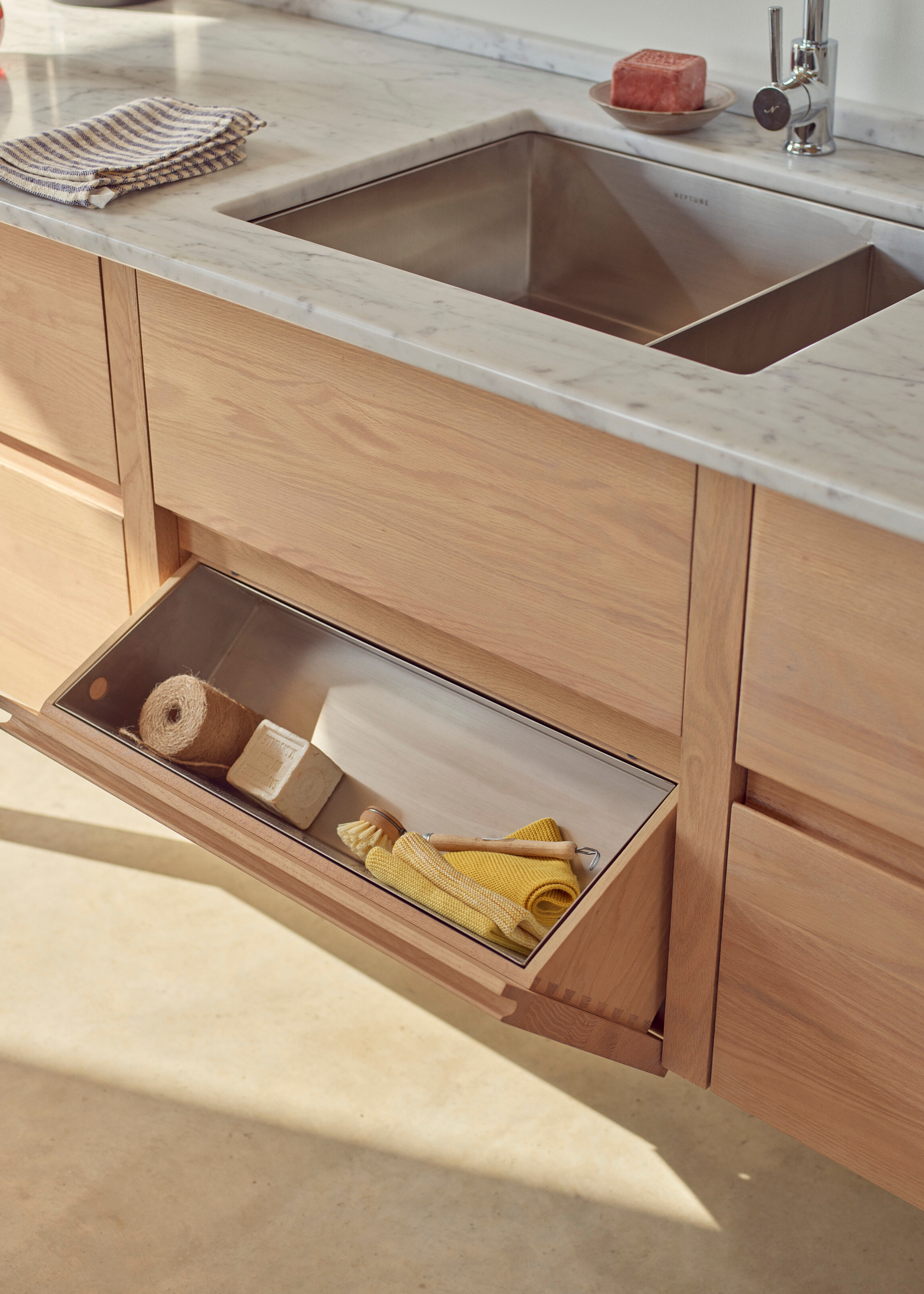 flap open storage beneath the kitchen sink with space for cleaning supplies