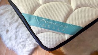 DreamCloud Premier Hybrid mattress review image shows the bottom corner of the mattress where the DreamCloud logo sticker is attached in blue
