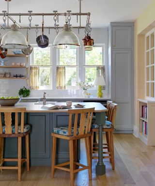 Pot hanger with integrated lighting above a kitchen island