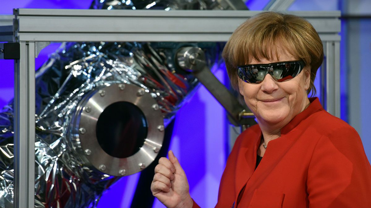 German Chancellor Angela Merkel wears safety goggles while watching an experiment in Koln