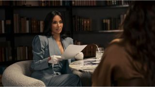 Stylishly-dressed attorney Allura (Kim Kardashian) sits across from a client in a book-lined room in a still from new legal drama All's Fair.