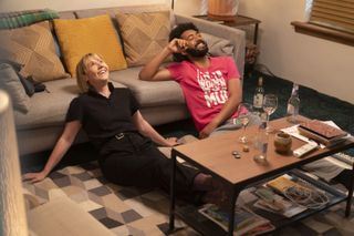 Karen Pirie (Lauren Lyle) and Phil Parhatka (Zach Wyatt) relaxing in a living room